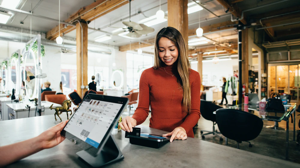 Canadian small business owner discussing service estimates with a customer in a local store